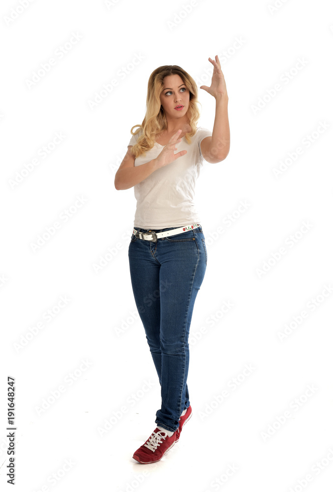 full length portrait of blonde girl wearing white shirt and jeans. standing pose, isolated on white studio background. full length portrait of blonde girl wearing white shirt and jeans. standing pose, isolated on white studio background.