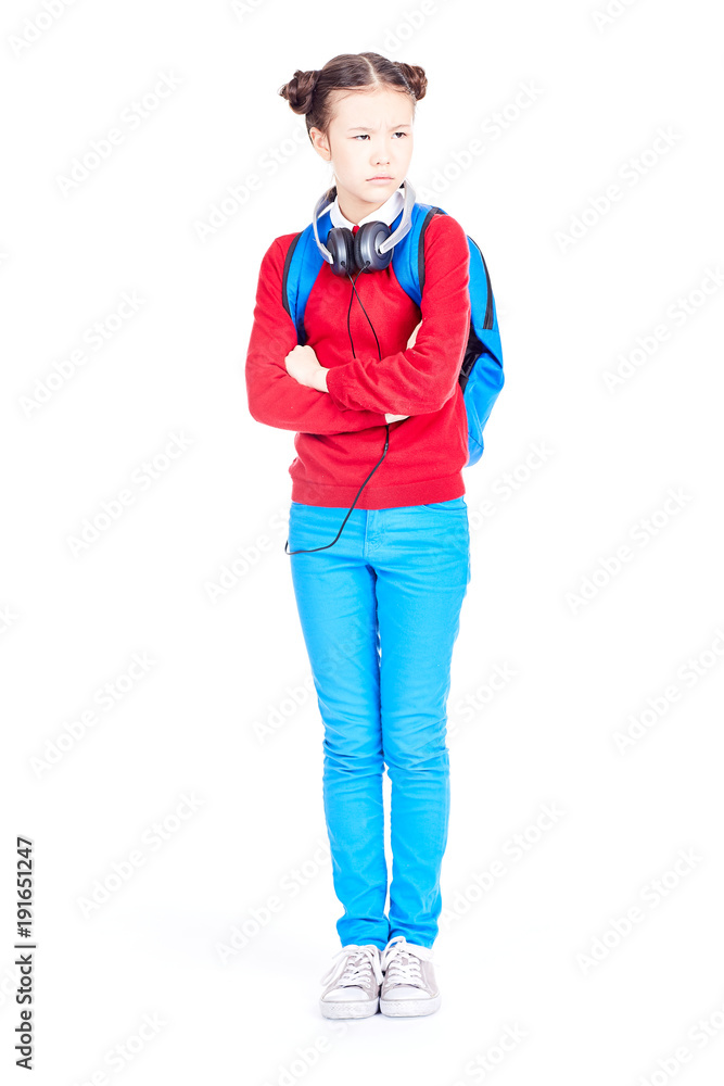 Fototapeta premium Portrait of Asian school girl posing on white background with backpack and headphones around her neck