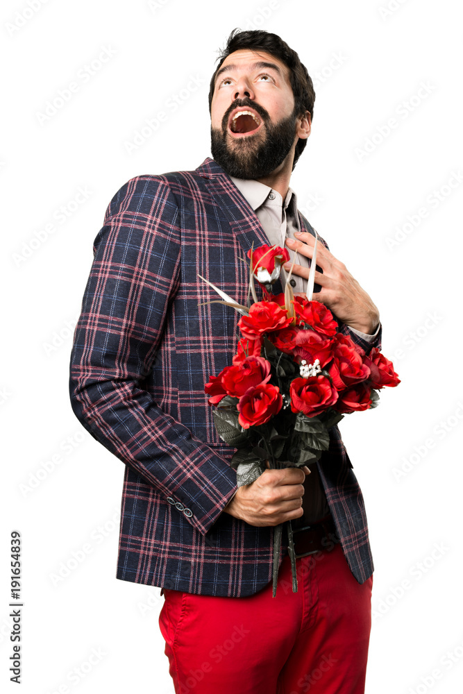 Surprised Well dressed man holding flowers on white background Surprised Well dressed man holding flowers on white background