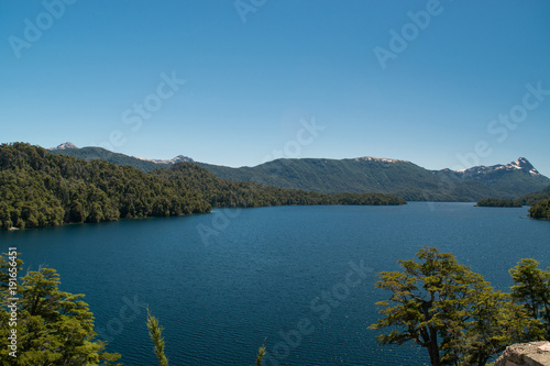 Landscape of a lake with island, with snowy mountain and blue sky