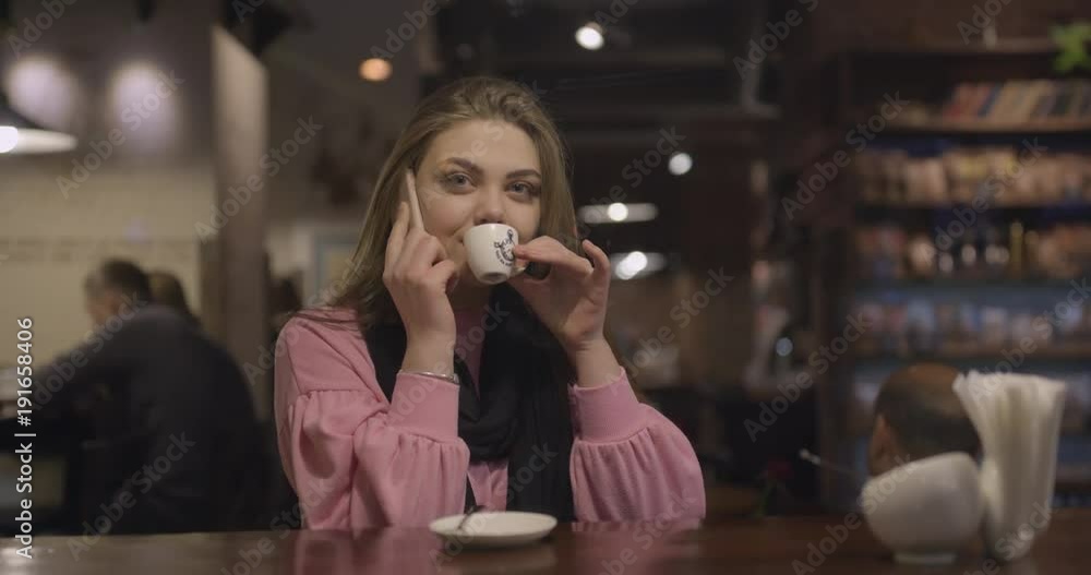 Woman with smartphone drinking coffee in cafe Woman with smartphone drinking coffee in cafe