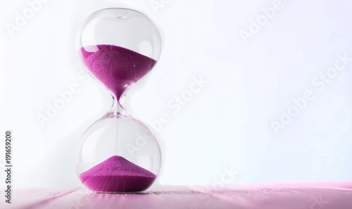 Hourglass with pink sand.