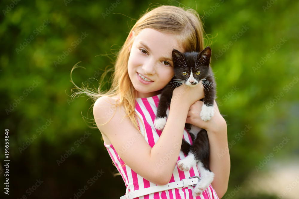 Cute little girl with her pet kitten on warm summer day. Kids and animals. Cute little girl with her pet kitten on warm summer day. Kids and animals.