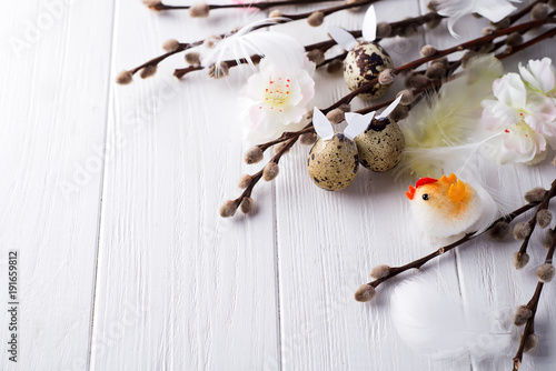 Easter quail eggs with hare ears and willow branch photo