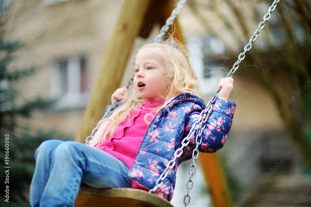 Cute little girl having fun on a swing on beautiful spring day. Cute little girl having fun on a swing on beautiful spring day.