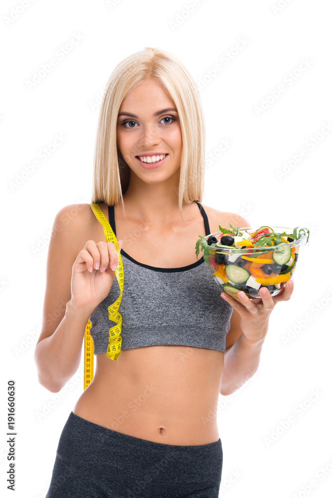 Woman in sportswear with tape measure and salad, isolated Woman in sportswear with tape measure and salad, isolated