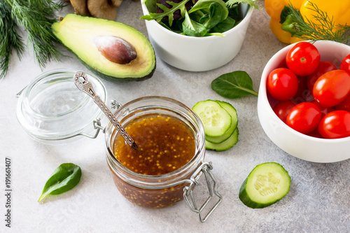 Photos Superfoods and homemade salad dressing vinaigrette with mustard, honey, balsamic vinegar and olive oil on a stone or slate background