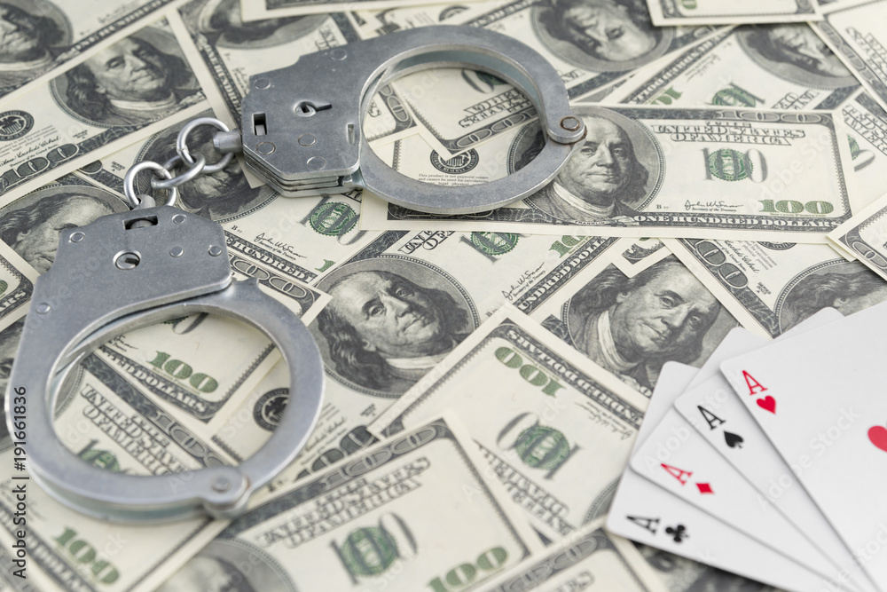 banknotes of dollars, handcuffs, four ace of playing cards. gambling. law violation. ban on gambling banknotes of dollars, handcuffs, four ace of playing cards. gambling. law violation. ban on gambling