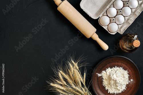 Preparation cooking baking kitchen table brown dishes ware fresh grocery different ingredients: eggs, flour, oil, stuff top view photo