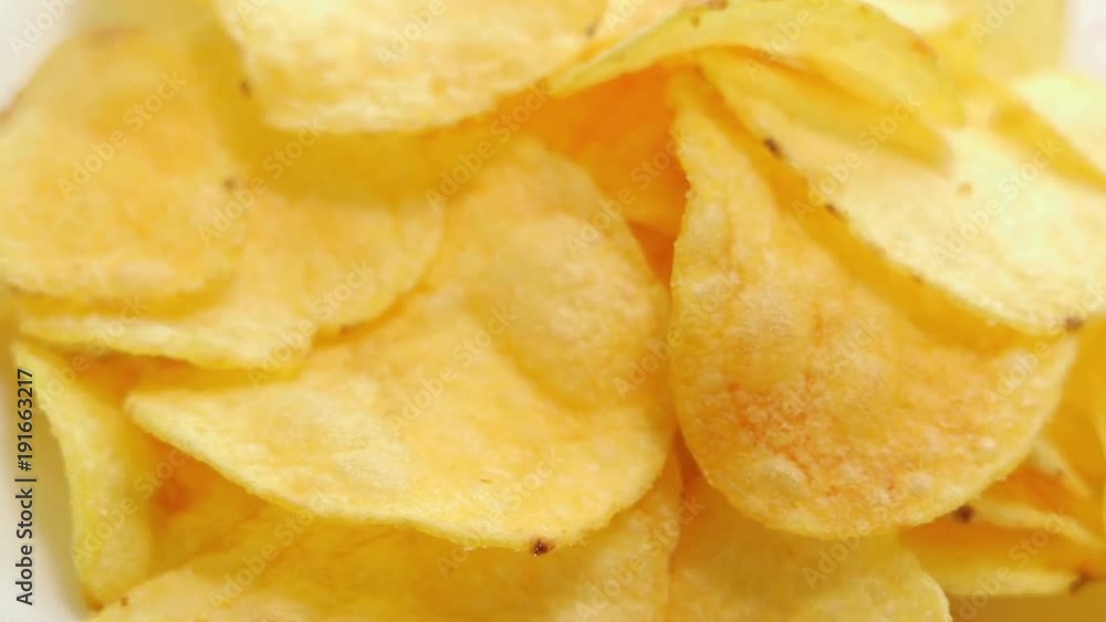 Homemade potato chips. Fast food. Popular junk food. Potato tubers and chips rotate smoothly on bamboo napkin. Diabetic diet. Homemade potato chips. Fast food. Popular junk food. Potato tubers and chips rotate smoothly on bamboo napkin. Diabetic diet.