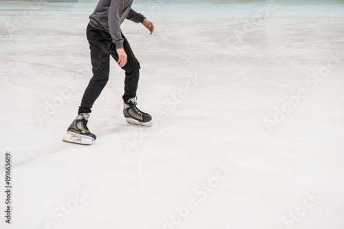 cropped shot of skates ice skating on rink