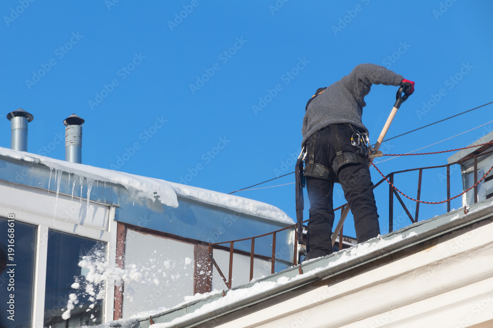 Work cleans the roof of the house from snow