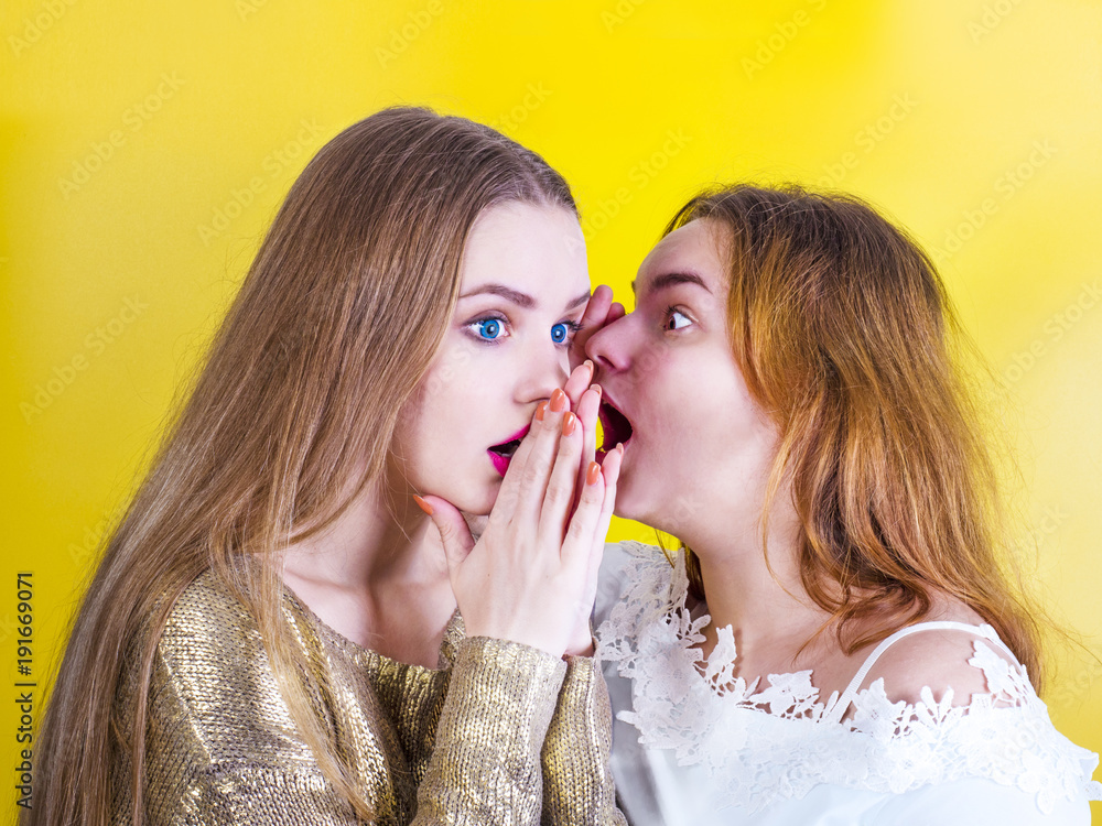 Foto Stock Young girl telling her best friend private secret. Girlfriend  listening with surprised expression on face. Best friends gossip about  people they know, telling latest rumors, sharing personal news. | Adobe