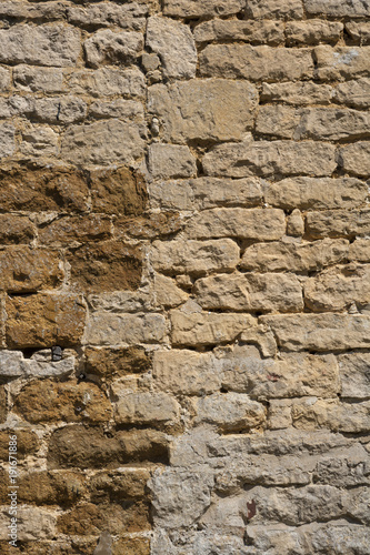 An old weathered stone wall needs repairs. Construction full frame texture background.