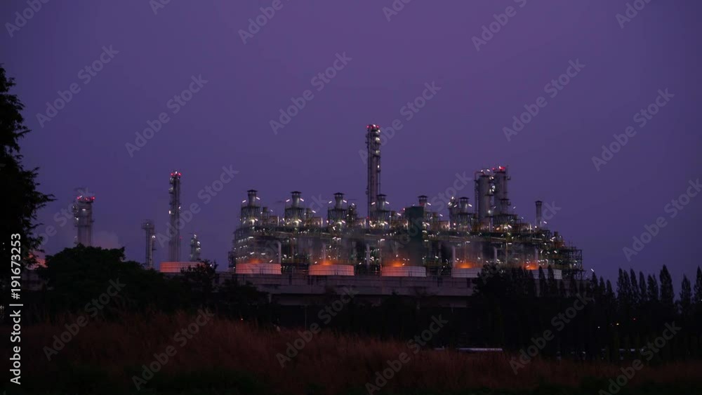 Oil and gas refinery at twilight - foggy smoke from heavy industry - Time lapse
