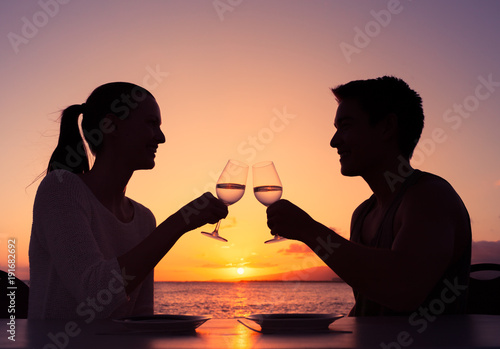 Man woman having romantic sunset dinner on the beach.