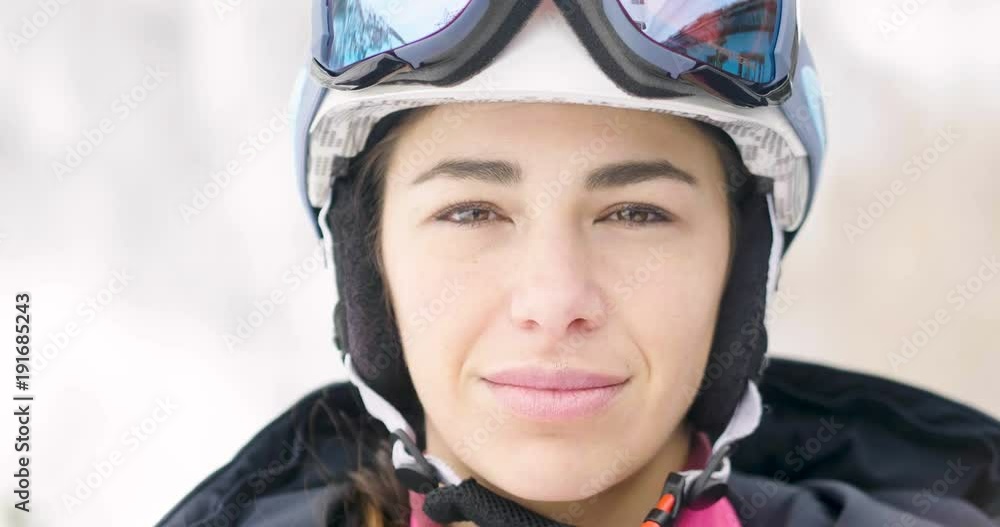 Portrait of a smiling skier on vacation in the mountains, behind her you can see the snow-covered mountain. Concept of: holidays, sport, passion, mountain. Portrait of a smiling skier on vacation in the mountains, behind her you can see the snow-covered mountain. Concept of: holidays, sport, passion, mountain.
