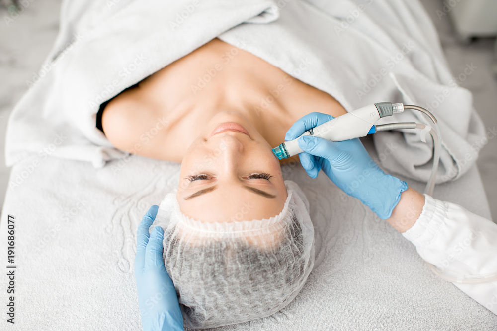 Young woman during the facial treatment procedure in the cosmetology office Young woman during the facial treatment procedure in the cosmetology office