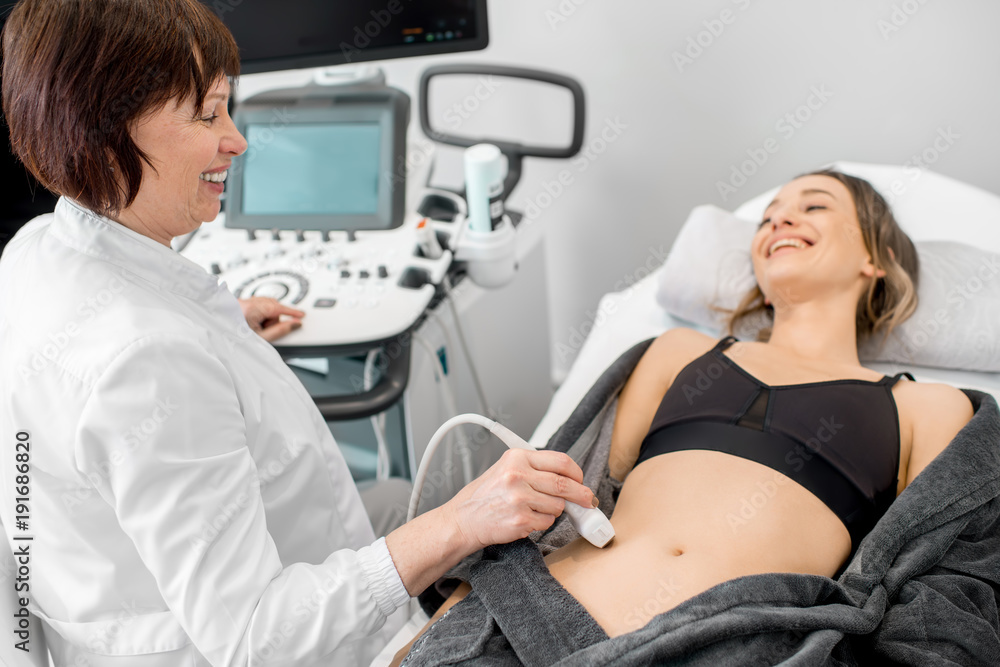 Φωτογραφία Senior doctor making an ultrasound examination to a young woman patient