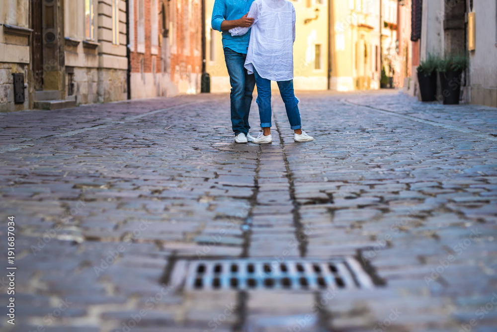 a guy and a girl are on an old cobblestone street in Europe