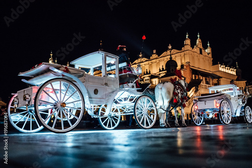 The old square of the night krakow with horse-drawn carriages