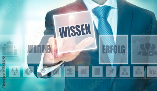 A businessman pressing a Knowledge "Wissen" button in German on