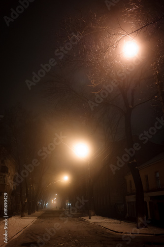 Picture of gloomy night with street lights and fog. Low light image.