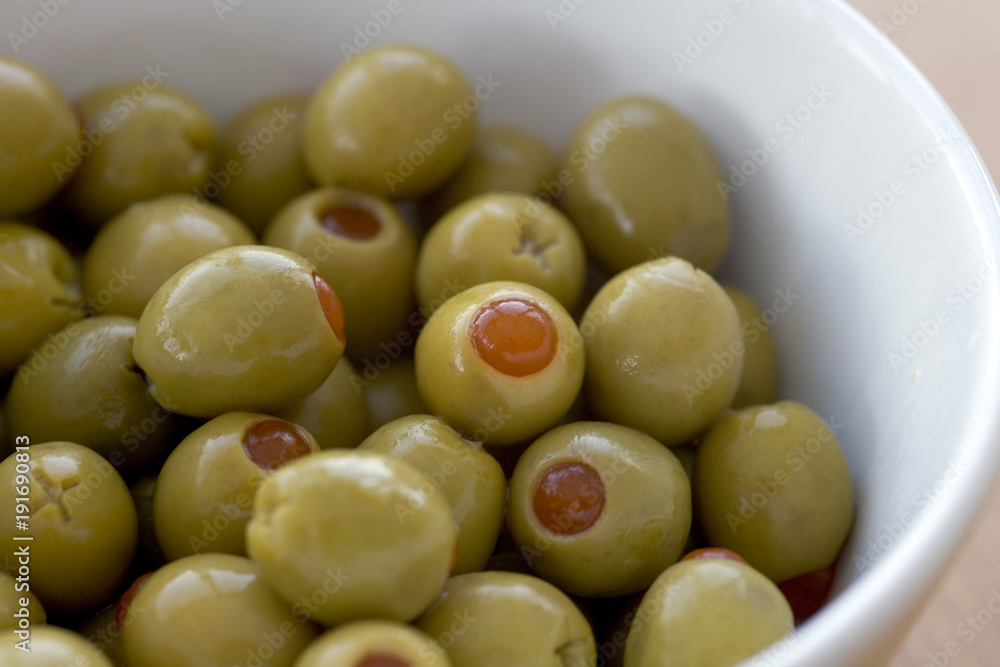 Pimento stuffed green olives in a white bowl Pimento stuffed green olives in a white bowl