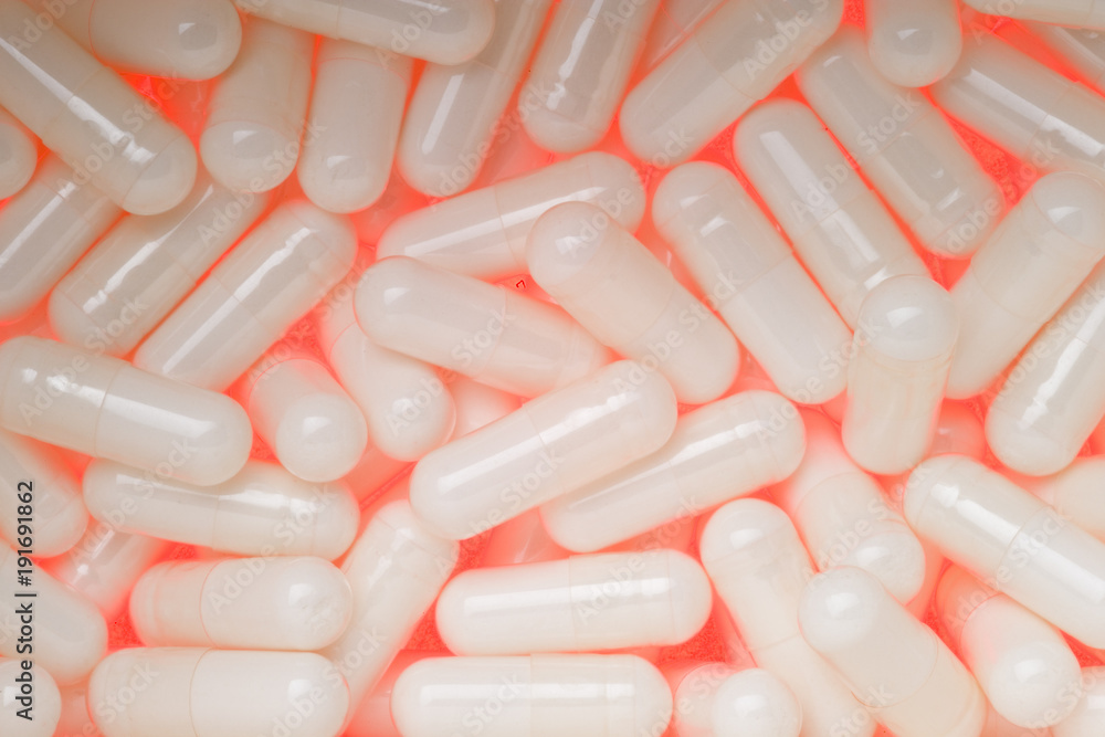 Backlit Glucosamine Sulphate capsules glowing close up Backlit Glucosamine Sulphate capsules glowing close up