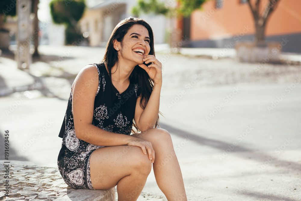 Beautiful young woman sitting in the street Beautiful young woman sitting in the street