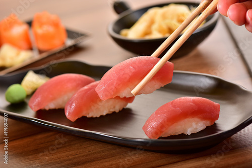 Chopsticks holding a Tuna nigiri sushi