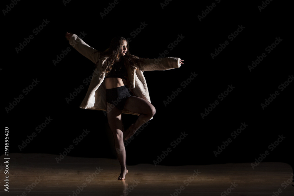 woman dancer with white coat in one leg