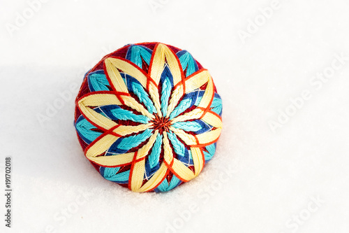 Bright decorative ball of the temari lie on the snow in the winter