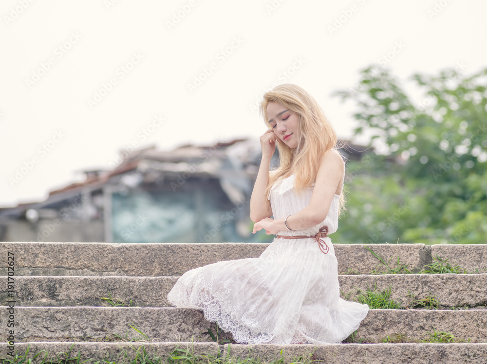 Beautiful Chinese young girl wearing a white dress in summer park. Outdoor fashion portrait of glamour young Chinese cheerful stylish lady. Emotions, people, beauty and lifestyle concept. Beautiful Chinese young girl wearing a white dress in summer park. Outdoor fashion portrait of glamour young Chinese cheerful stylish lady. Emotions, people, beauty and lifestyle concept.