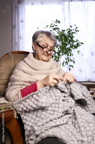 Close-up Portrait of Senior Woman Knitting with Wool, Grandmothers Hands Knit Wool Yarn. Craft is Hobby of Old Women. Senior Lady, Happy Granny Knitted Sweater Handmade.  © Olga