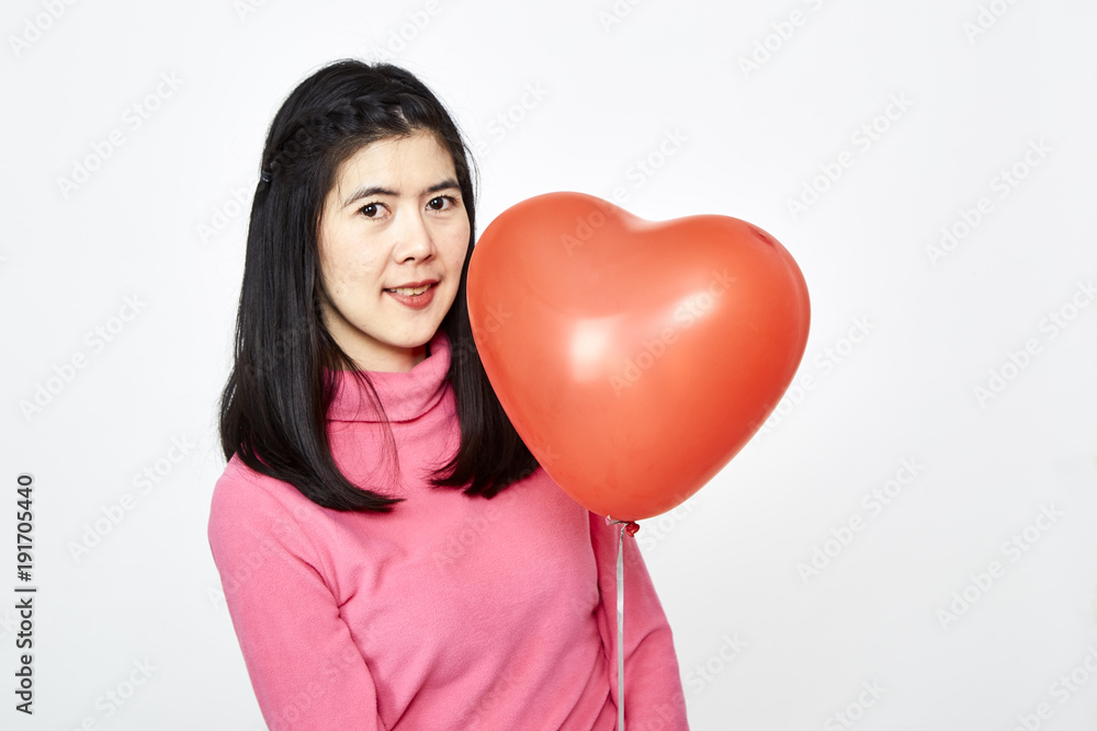 Woman holding red heart shaped balloon Woman holding red heart shaped balloon