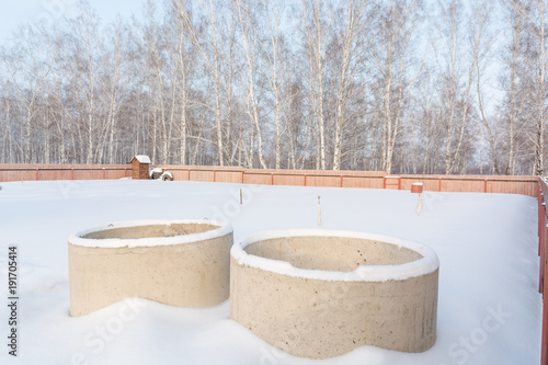 Concrete rings in the snow. The rings for the well stand on the snow in winter. © Sergey_Siberia88