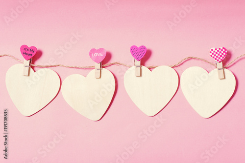 White hearts with clothes pegs on pink background, Valentine concept