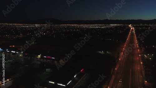 Aerial establishing shot of a large city with lights at night dolly