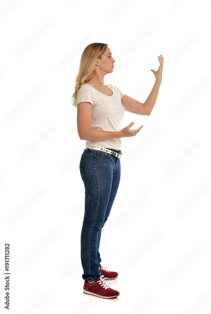 full length portrait of blonde girl wearing simple shirt and jeans, standing pose on white background. full length portrait of blonde girl wearing simple shirt and jeans, standing pose on white background.