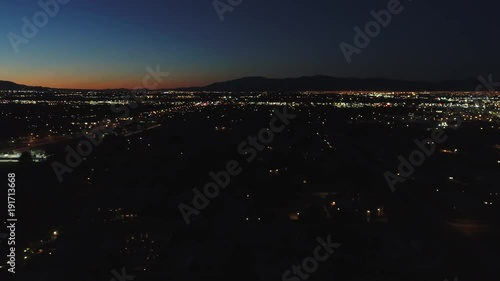 Aerial establishing shot of large city with lights at night