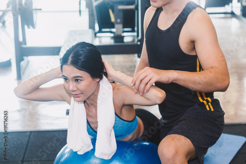 Handsome trainer and fitness woman at the gym.fitness and lifestyle concept