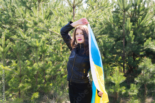 The model in black clothes holds the flag of ukraine