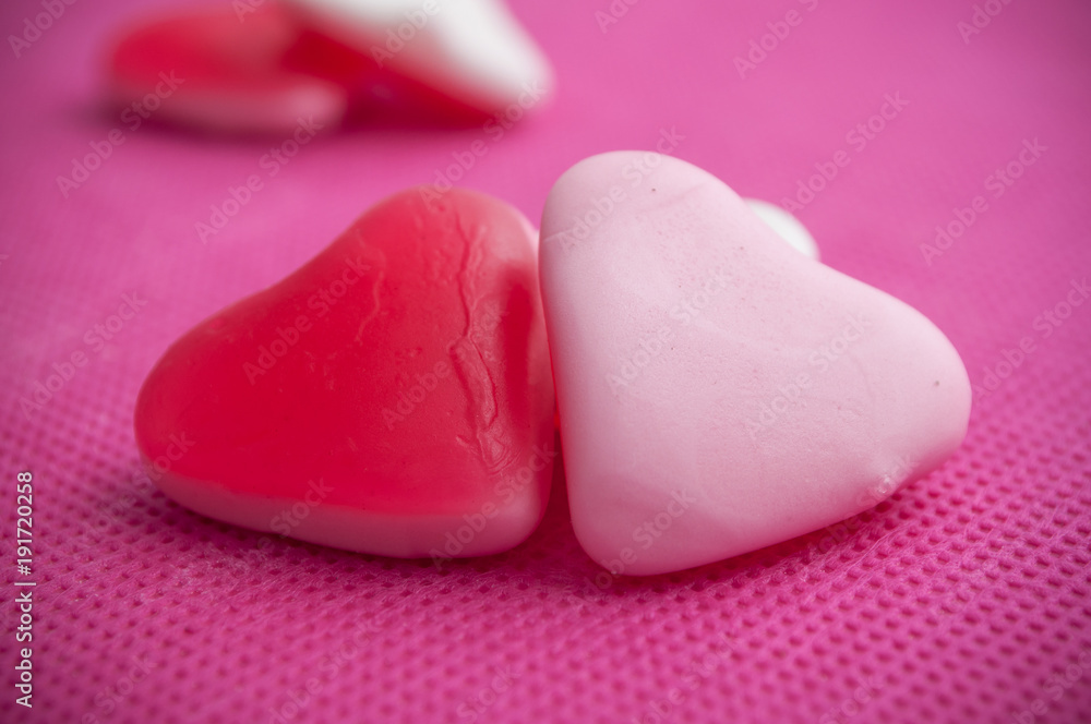 Obraz premium bonbons en forme de coeur sur fond rose