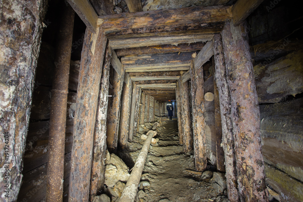 Underground abandoned ore mine shaft tunnel gallery with wooden timbering Underground abandoned ore mine shaft tunnel gallery with wooden timbering