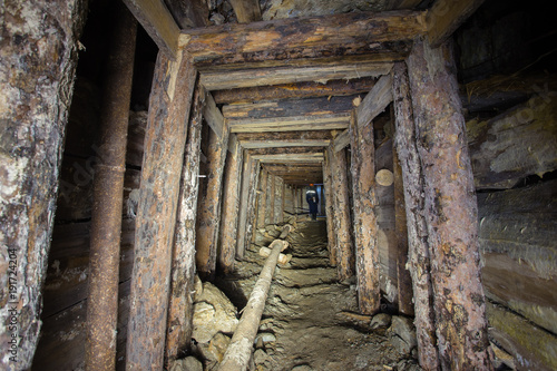 Underground abandoned ore mine shaft tunnel gallery with wooden timbering © Mishainik