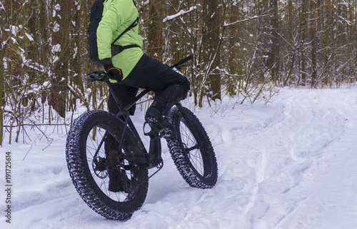 Fat bike also called fat bike or fat-tire bike - Cycling on large wheels in the winter forest.