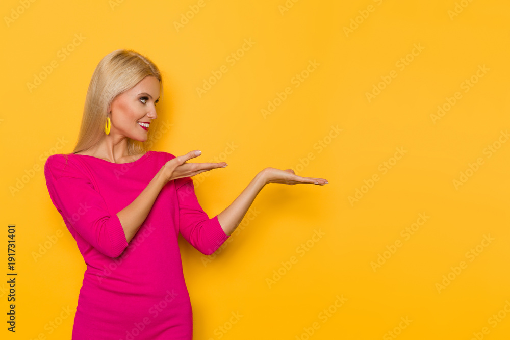 Smiling Woman In Pink Sweater Is Presenting And Looking Away Smiling Woman In Pink Sweater Is Presenting And Looking Away