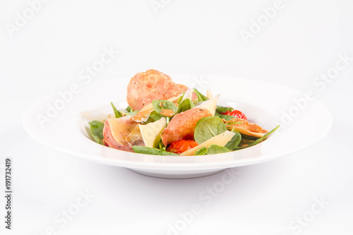 Baby spinach, dry sausage, matured cheese, roast tomatoes, thyme-balsamic vinaigrette salad on a white background