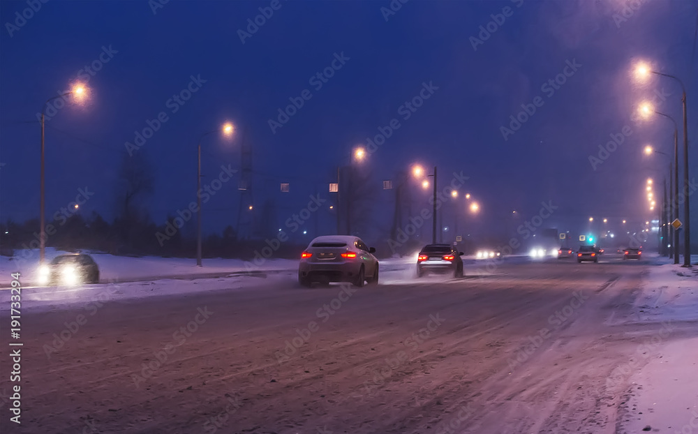 Cars drive along snow-covered road.
